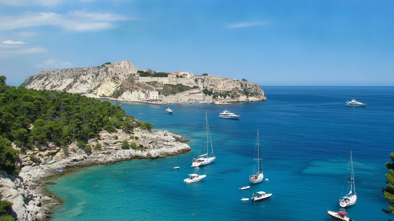 Mare turchese e barche alla fonda alle Isole Tremiti, con l'isola di San Nicola sullo sfondo