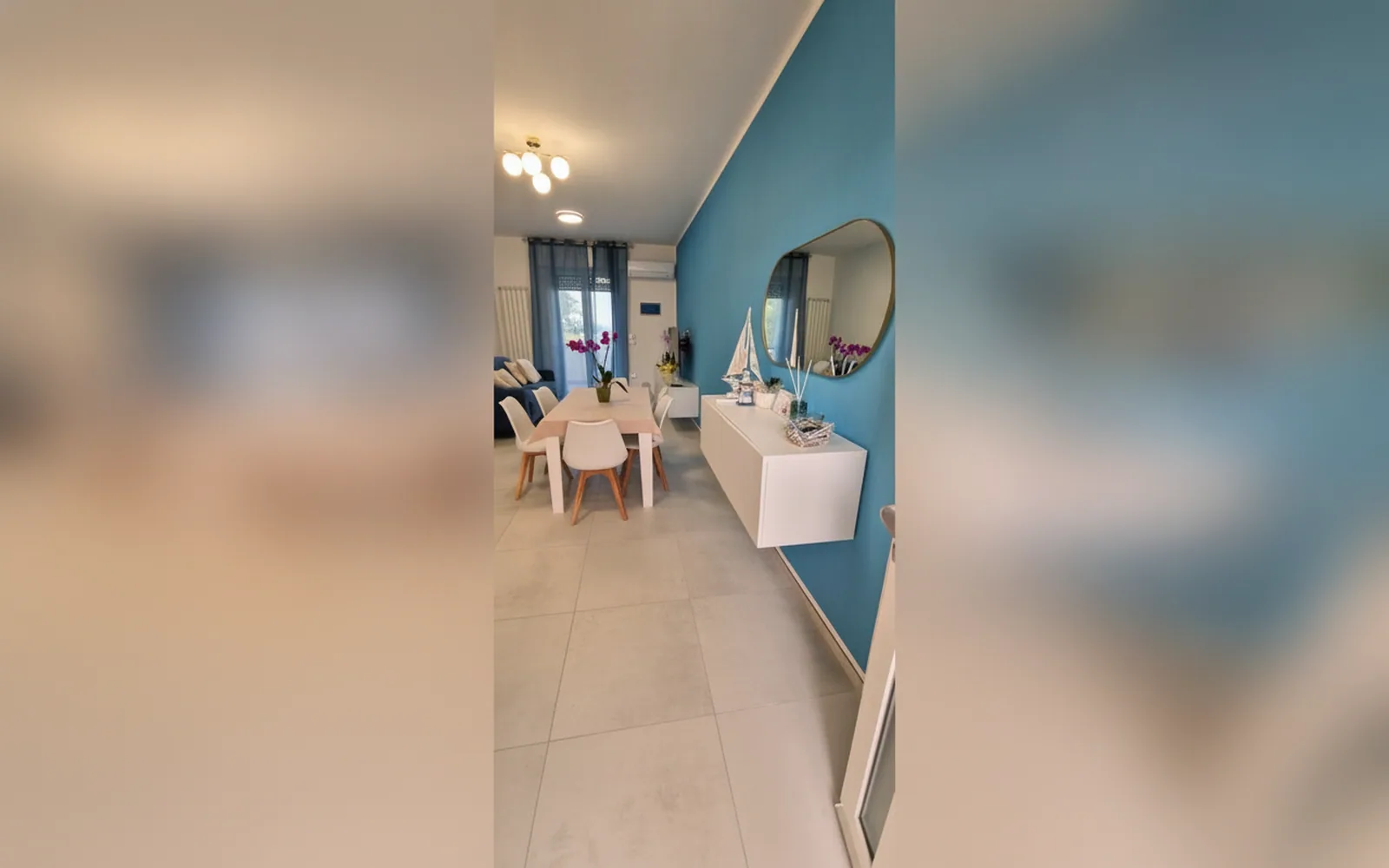 Il soggiorno di casa Vacanze Yolo, con tavolo da pranzo e cucina a vista